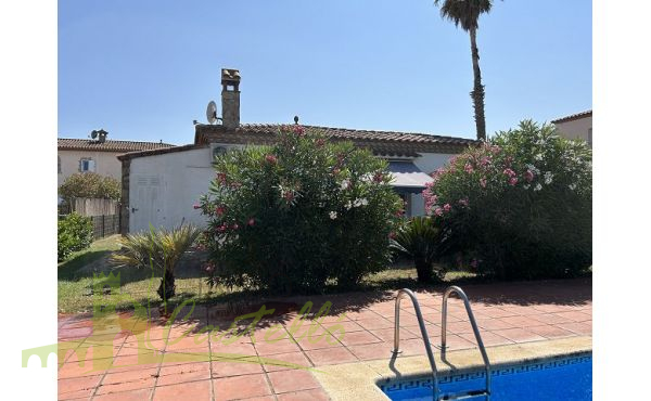 Piscina comunitaria con fachada de la casa